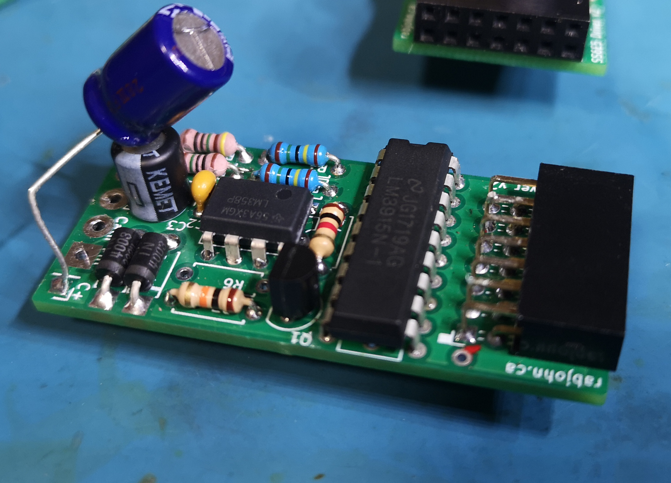 Hand-soldered PCB with capacitors, resistors, SOIC IC, and connectors