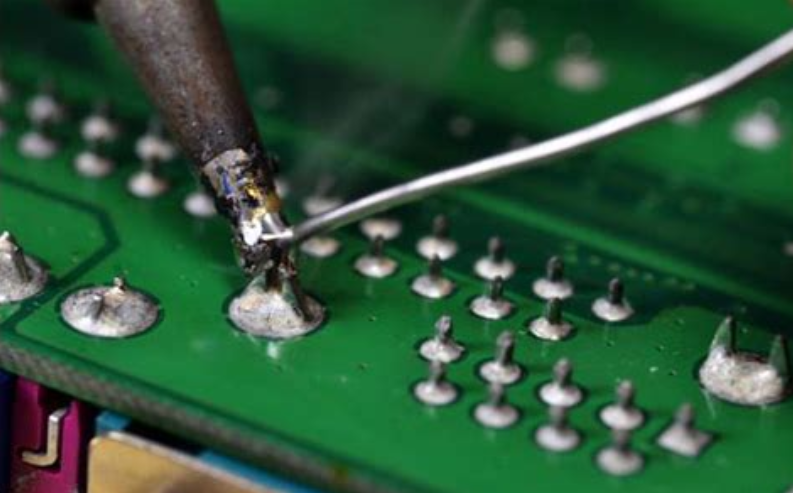 Hand soldering a through hole joint  on a PCB
